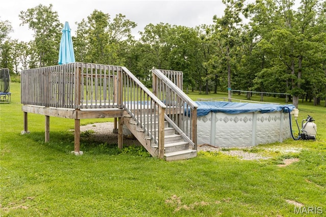 465 County Road 5120, Salem, MO 65560 - view of swimming pool with a trampoline, a wooden deck, stairs, a covered pool, and a lawn