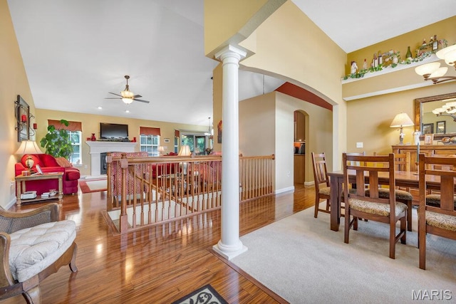 1020 Oak Creek Ln, Waterloo, IL 62298 - dining space featuring ceiling fan, arched walkways, wood finished floors, a fireplace, and decorative columns