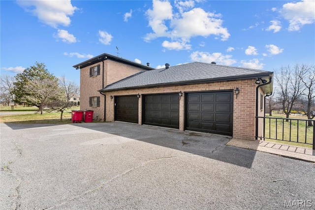 305 Ridge Dr, Sikeston, MO 63801 - view of side of home featuring brick siding, driveway, a garage, and roof with shingles