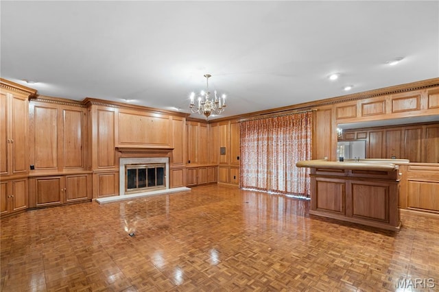 305 Ridge Dr, Sikeston, MO 63801 - unfurnished living room featuring a chandelier, a glass covered fireplace, and wood walls