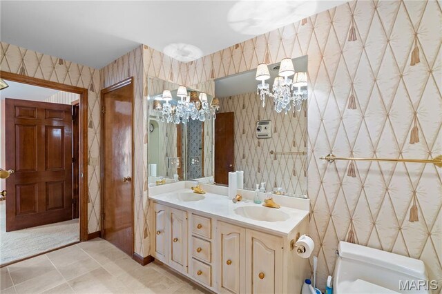 305 Ridge Dr, Sikeston, MO 63801 - bathroom with wallpapered walls, toilet, a chandelier, and double vanity