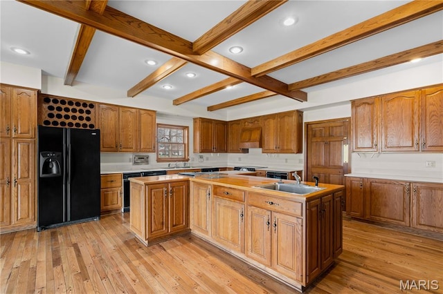 305 Ridge Dr, Sikeston, MO 63801 - kitchen with black refrigerator with ice dispenser, a kitchen island with sink, a sink, light wood-style flooring, and beamed ceiling
