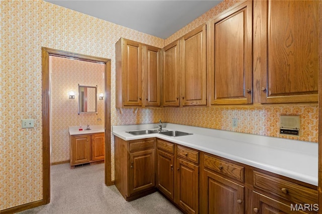 305 Ridge Dr, Sikeston, MO 63801 - kitchen with a sink, brown cabinetry, light countertops, wallpapered walls, and light colored carpet