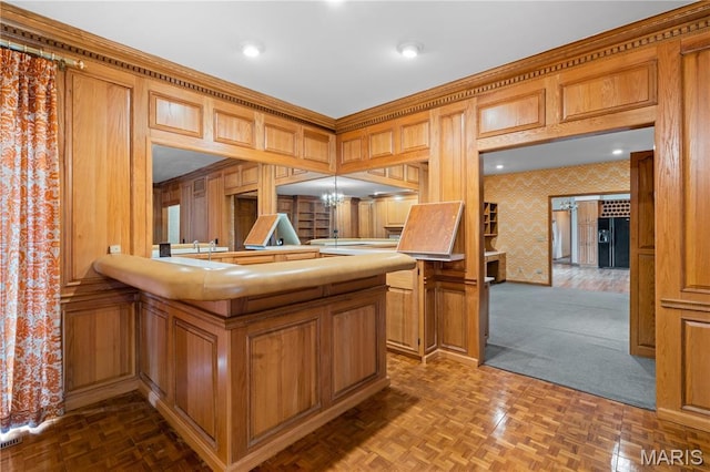 305 Ridge Dr, Sikeston, MO 63801 - kitchen featuring wallpapered walls, a peninsula, a chandelier, and brown cabinets