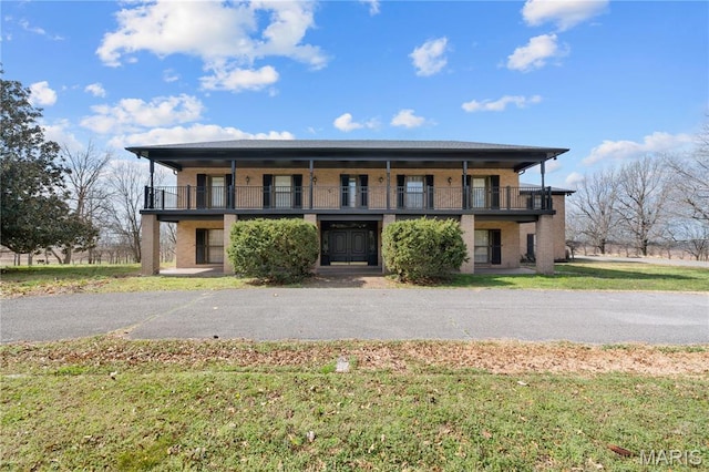 305 Ridge Dr, Sikeston, MO 63801 - view of front of house with brick siding, a balcony, and a front yard