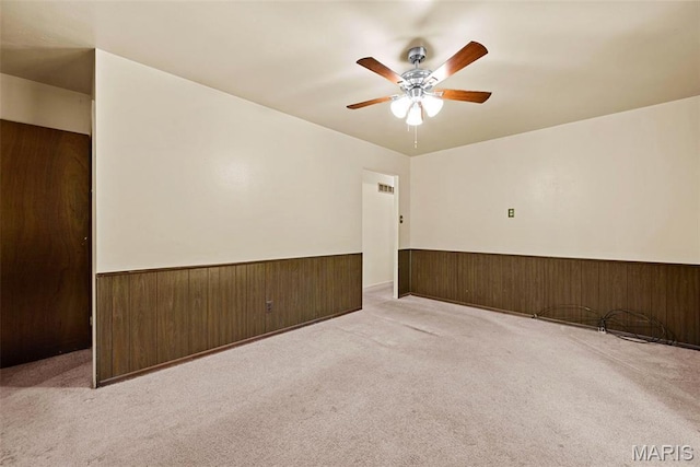 1466 Friar Tuck Ln, Lemay Township, MO 63125 - carpeted empty room featuring a wainscoted wall, ceiling fan, and wood walls
