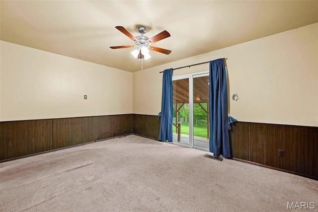 1466 Friar Tuck Ln, Lemay Township, MO 63125 - carpeted empty room featuring a wainscoted wall, wood walls, and ceiling fan