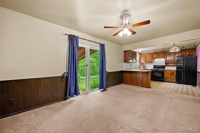 1466 Friar Tuck Ln, Lemay Township, MO 63125 - kitchen with black appliances, a peninsula, a wainscoted wall, open floor plan, and light carpet