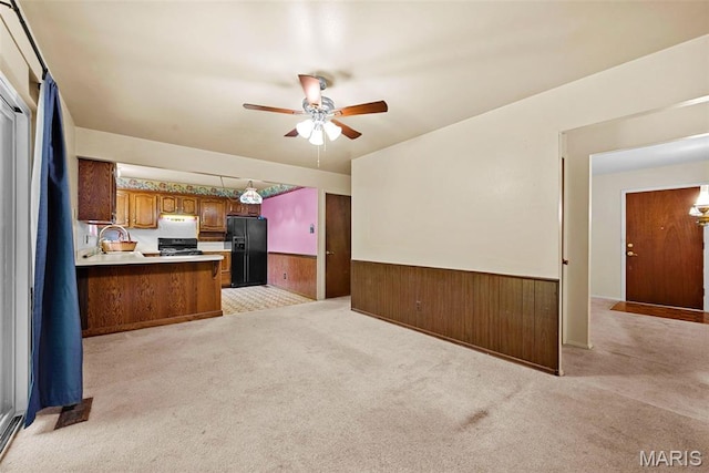 1466 Friar Tuck Ln, Lemay Township, MO 63125 - kitchen with black fridge, a wainscoted wall, open floor plan, range, and ceiling fan