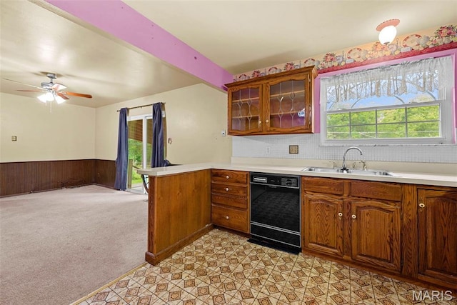 1466 Friar Tuck Ln, Lemay Township, MO 63125 - kitchen with black dishwasher, a peninsula, a wainscoted wall, light countertops, and glass insert cabinets
