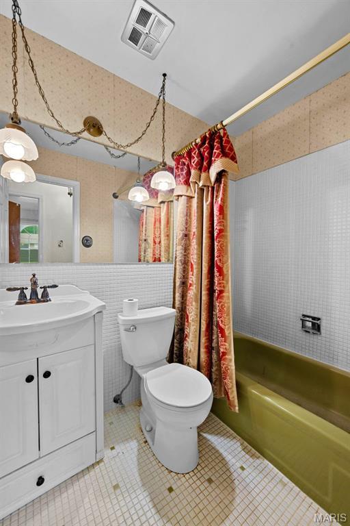 1466 Friar Tuck Ln, Lemay Township, MO 63125 - bathroom featuring shower / bath combo with shower curtain, tile patterned flooring, vanity, tile walls, and wallpapered walls