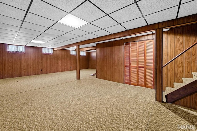 1466 Friar Tuck Ln, Lemay Township, MO 63125 - basement featuring carpet floors, wood walls, stairs, and a paneled ceiling
