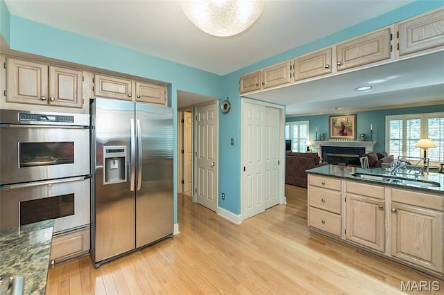 3 Deer Creek Woods, Ladue, MO 63124 - kitchen featuring stainless steel appliances, a fireplace, light wood-style floors, and light brown cabinetry
