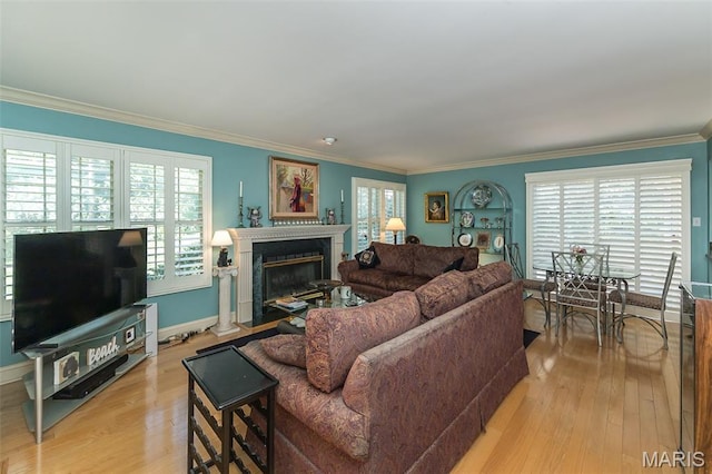 3 Deer Creek Woods, Ladue, MO 63124 - living area with ornamental molding, a fireplace with flush hearth, healthy amount of natural light, and light wood-type flooring