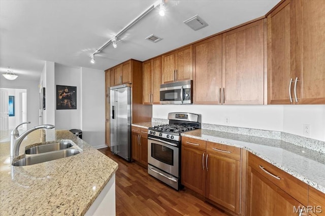 4909 Laclede Ave Unit 806, Saint Louis, MO 63108 - kitchen with stainless steel appliances, brown cabinetry, dark wood-style floors, rail lighting, and light stone counters