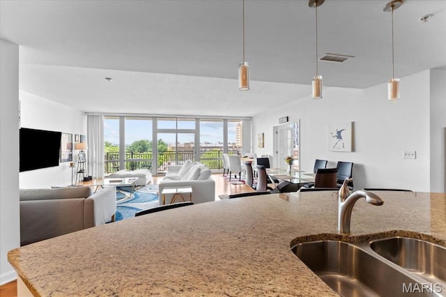 4909 Laclede Ave Unit 806, Saint Louis, MO 63108 - kitchen featuring open floor plan, light stone countertops, and decorative light fixtures