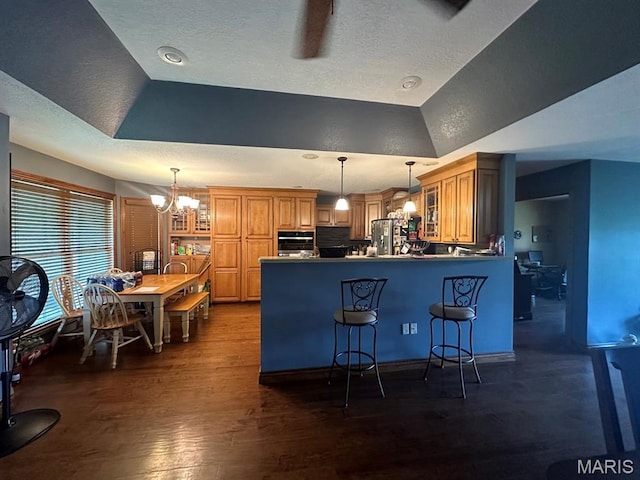 11355 Satmoore Rd, Dexter, MO 63841 - kitchen featuring a raised ceiling, stainless steel appliances, a peninsula, glass insert cabinets, and a breakfast bar