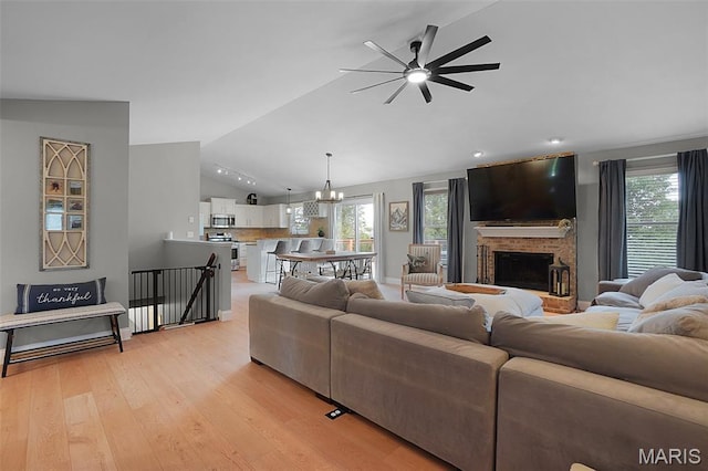 3837 Bedford Pointe Dr, Wentzville, MO 63385 - living area featuring vaulted ceiling, ceiling fan, a chandelier, plenty of natural light, and a fireplace with raised hearth