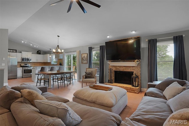 3837 Bedford Pointe Dr, Wentzville, MO 63385 - living area featuring a ceiling fan, vaulted ceiling, a chandelier, plenty of natural light, and a fireplace