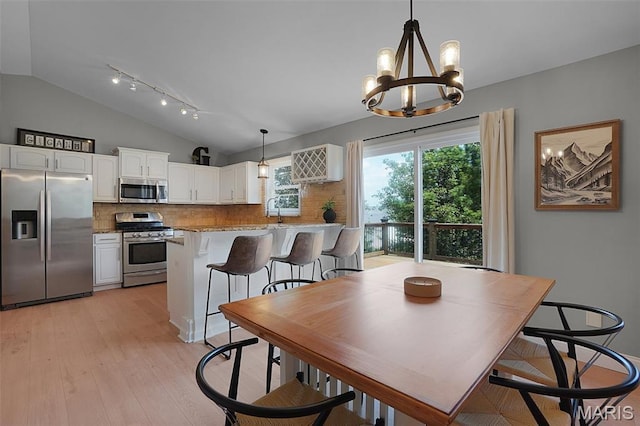 3837 Bedford Pointe Dr, Wentzville, MO 63385 - dining space with lofted ceiling, a chandelier, light wood-type flooring, and track lighting