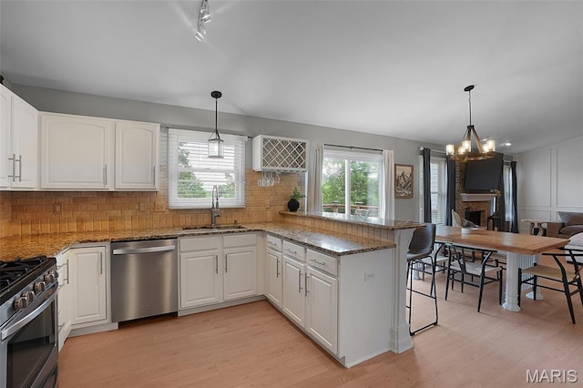 3837 Bedford Pointe Dr, Wentzville, MO 63385 - kitchen featuring stainless steel appliances, light wood finished floors, a peninsula, and a chandelier