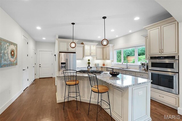 1316 Breezeridge Dr, Des Peres, MO 63131 - kitchen with stainless steel appliances, a sink, dark wood finished floors, light stone countertops, and recessed lighting