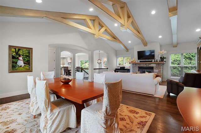 1316 Breezeridge Dr, Des Peres, MO 63131 - dining space featuring arched walkways, beam ceiling, baseboards, a stone fireplace, and high vaulted ceiling