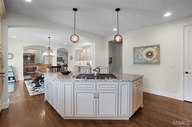 1316 Breezeridge Dr, Des Peres, MO 63131 - kitchen featuring arched walkways, stainless steel gas stovetop, dark wood-style flooring, light stone countertops, and recessed lighting