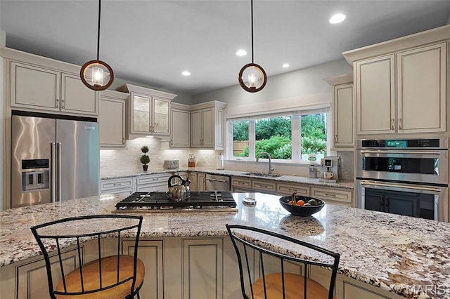 1316 Breezeridge Dr, Des Peres, MO 63131 - kitchen featuring appliances with stainless steel finishes, a sink, a kitchen bar, hanging light fixtures, and recessed lighting