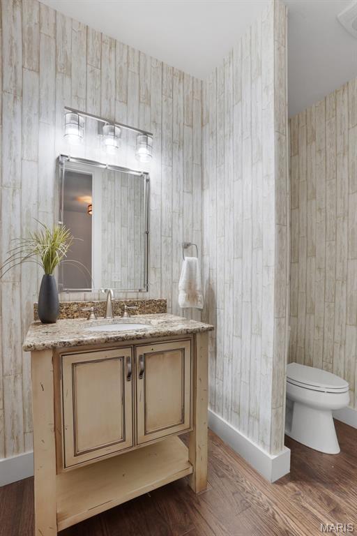 1316 Breezeridge Dr, Des Peres, MO 63131 - bathroom featuring toilet, wood finished floors, vanity, baseboards, and wood walls