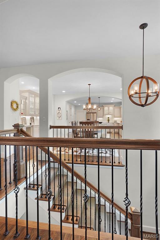1316 Breezeridge Dr, Des Peres, MO 63131 - hall featuring a chandelier, arched walkways, recessed lighting, and wood finished floors