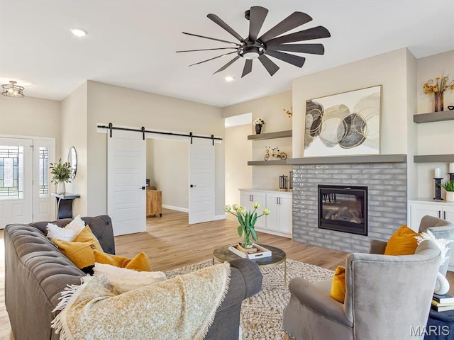 484 Hayden Dr, Waterloo, IL 62298 - living area with a barn door, a ceiling fan, light wood-type flooring, a brick fireplace, and recessed lighting