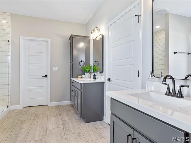 484 Hayden Dr, Waterloo, IL 62298 - bathroom with two vanities, baseboards, and tiled shower
