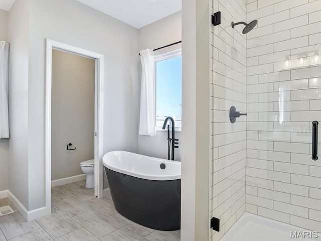 484 Hayden Dr, Waterloo, IL 62298 - bathroom featuring a freestanding tub, a stall shower, toilet, and baseboards