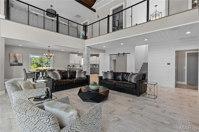 2262 Brown Rd, Van Buren, MO 63965 - living area featuring a high ceiling, a barn door, wood finished floors, baseboards, and a chandelier