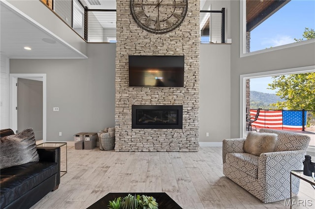 2262 Brown Rd, Van Buren, MO 63965 - living room with a towering ceiling, wood finished floors, a stone fireplace, and baseboards