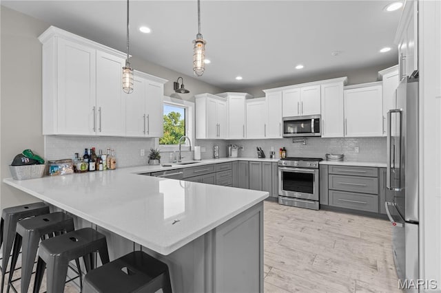 2262 Brown Rd, Van Buren, MO 63965 - kitchen with stainless steel appliances, gray cabinetry, a peninsula, light countertops, and decorative backsplash
