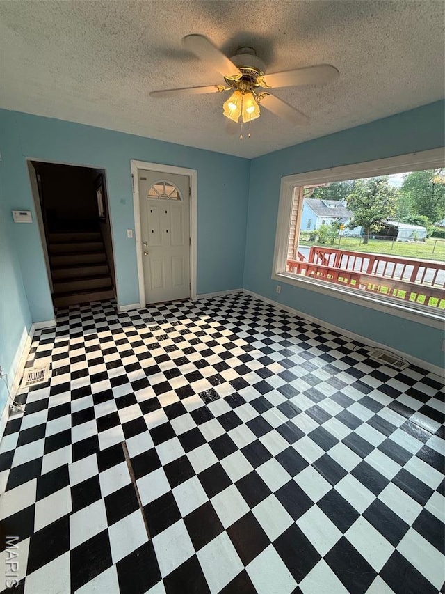 2213 Johnson St, Alton, IL 62002 - unfurnished room with stairway, a ceiling fan, a textured ceiling, baseboards, and tile patterned floors