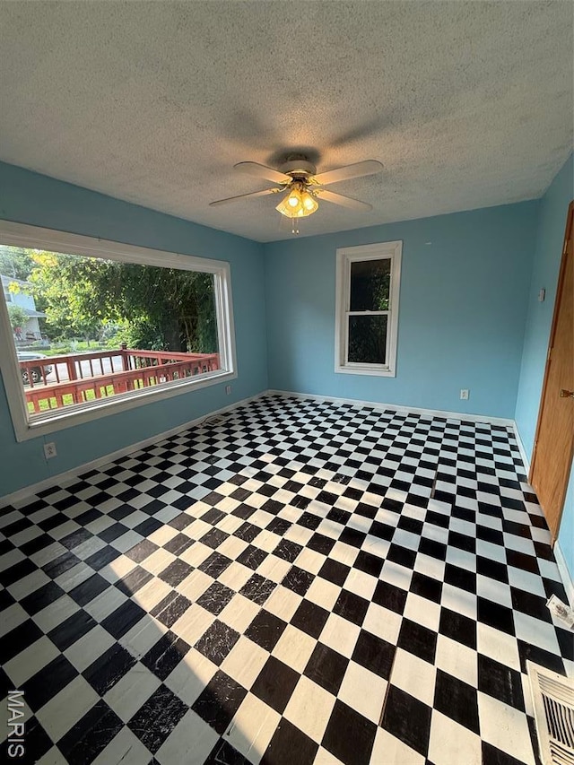 2213 Johnson St, Alton, IL 62002 - empty room with a textured ceiling, ceiling fan, and tile patterned floors