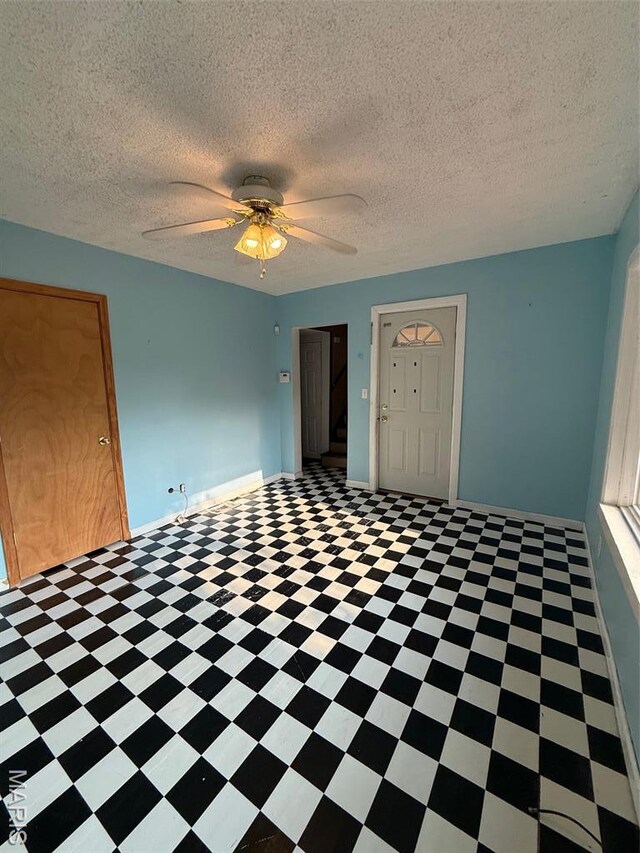 2213 Johnson St, Alton, IL 62002 - empty room featuring a ceiling fan, tile patterned floors, baseboards, and a textured ceiling