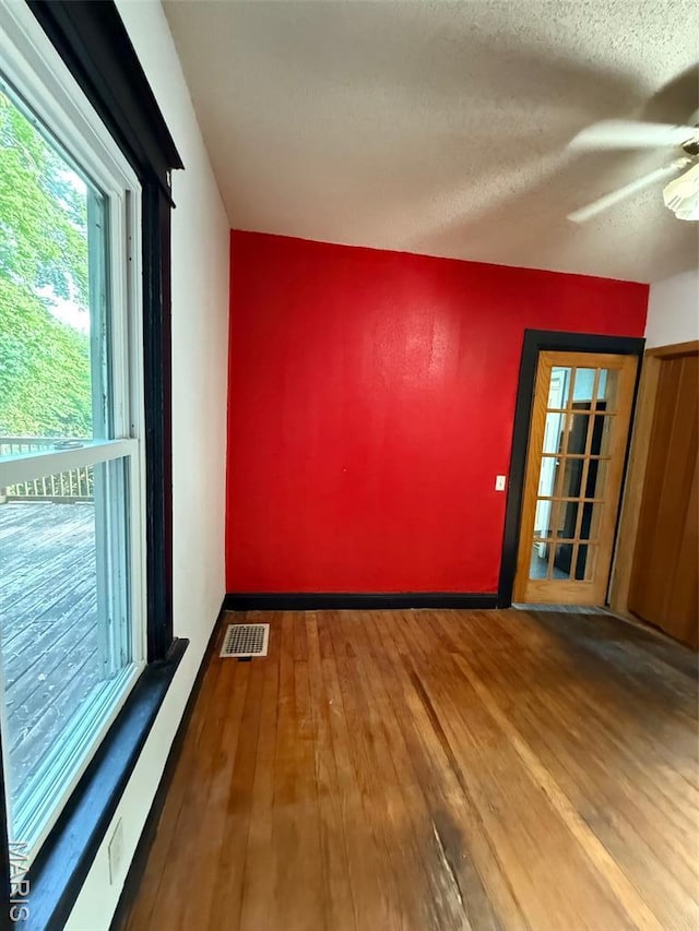 2213 Johnson St, Alton, IL 62002 - unfurnished room featuring wood-type flooring, healthy amount of natural light, ceiling fan, baseboards, and a textured ceiling