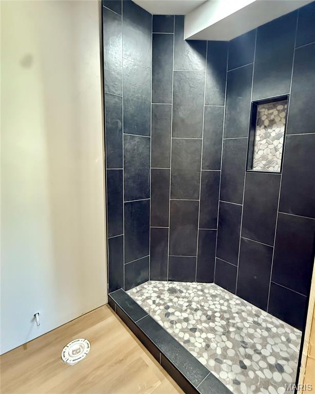 500 W Pacific St, Pacific, MO 63069 - bathroom featuring wood finished floors and tiled shower