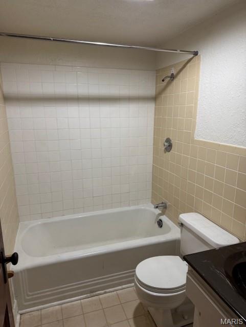 1804 N Oak St, Rolla, MO 65401 - bathroom with tile walls, toilet, tile patterned floors, washtub / shower combination, and vanity