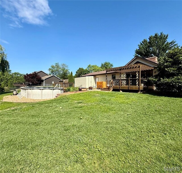 112 Cross Creek Dr, Bethalto, IL 62010 - view of grassy yard with a wooden deck, an outdoor pool, a storage shed, and a pergola