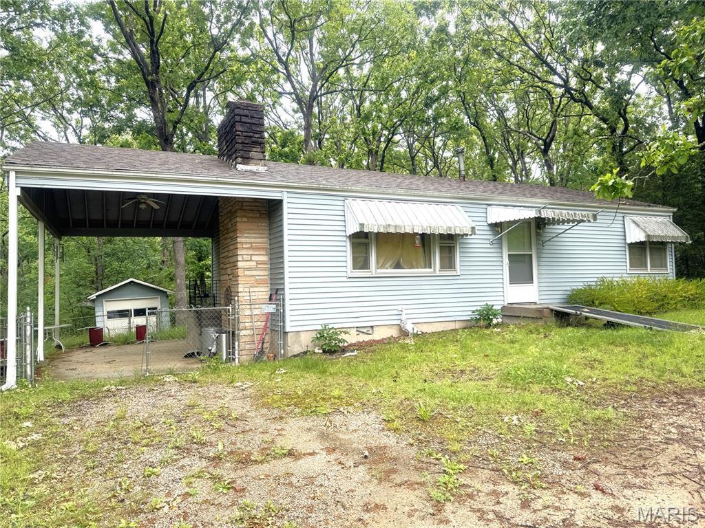 55 Indian Hills Dr, Cuba, MO 65453 - view of front of property with a chimney, an outbuilding, and roof with shingles