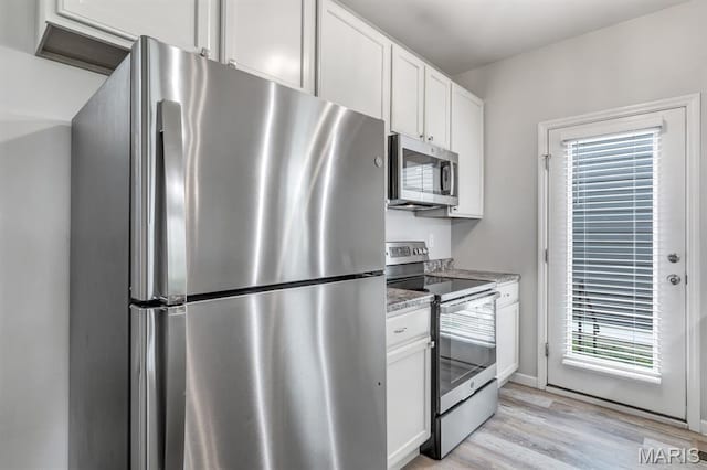 109 Starry Night Way, Saint Charles, MO 63301 - kitchen with stainless steel appliances, light wood-style floors, white cabinets, and light stone counters