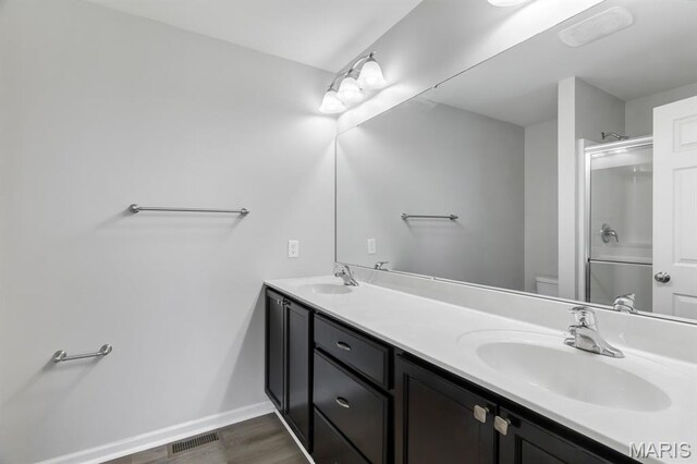 109 Starry Night Way, Saint Charles, MO 63301 - full bath featuring double vanity, a shower with shower door, and wood finished floors