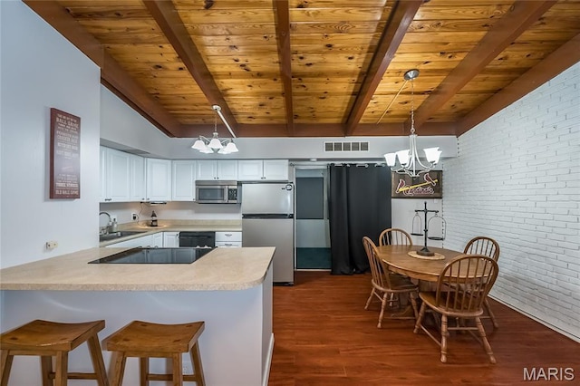 110 Coral Ter Unit 13, Ballwin, MO 63011 - kitchen with stainless steel appliances, a chandelier, brick wall, a peninsula, and wood ceiling with exposed beams