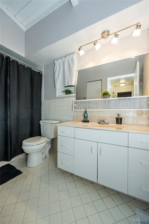 110 Coral Ter Unit 13, Ballwin, MO 63011 - full bathroom with vanity, tile patterned floors, toilet, and tile walls