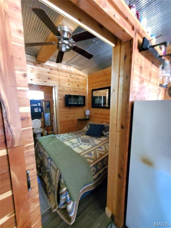 303 Arrowhead Trl, Hermann, MO 65041 - bedroom featuring wooden walls, freestanding refrigerator, wood finished floors, and lofted ceiling